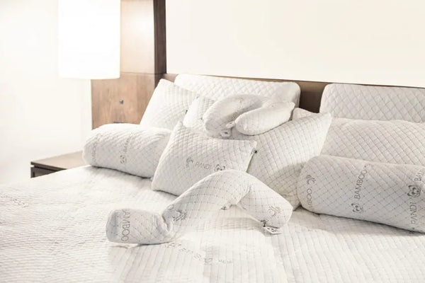 Almohada de Lactancia de Bambú: Comodidad y Ergonomía para Bebés, una variedad de almohadas de bambú colocadas en una cama, diseñadas para proporcionar soporte ergonómico y confort durante la lactancia.
