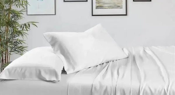 Dormitorio moderno con sábanas de bambú blancas y decoración minimalista, reflejando los beneficios de dormir bien.