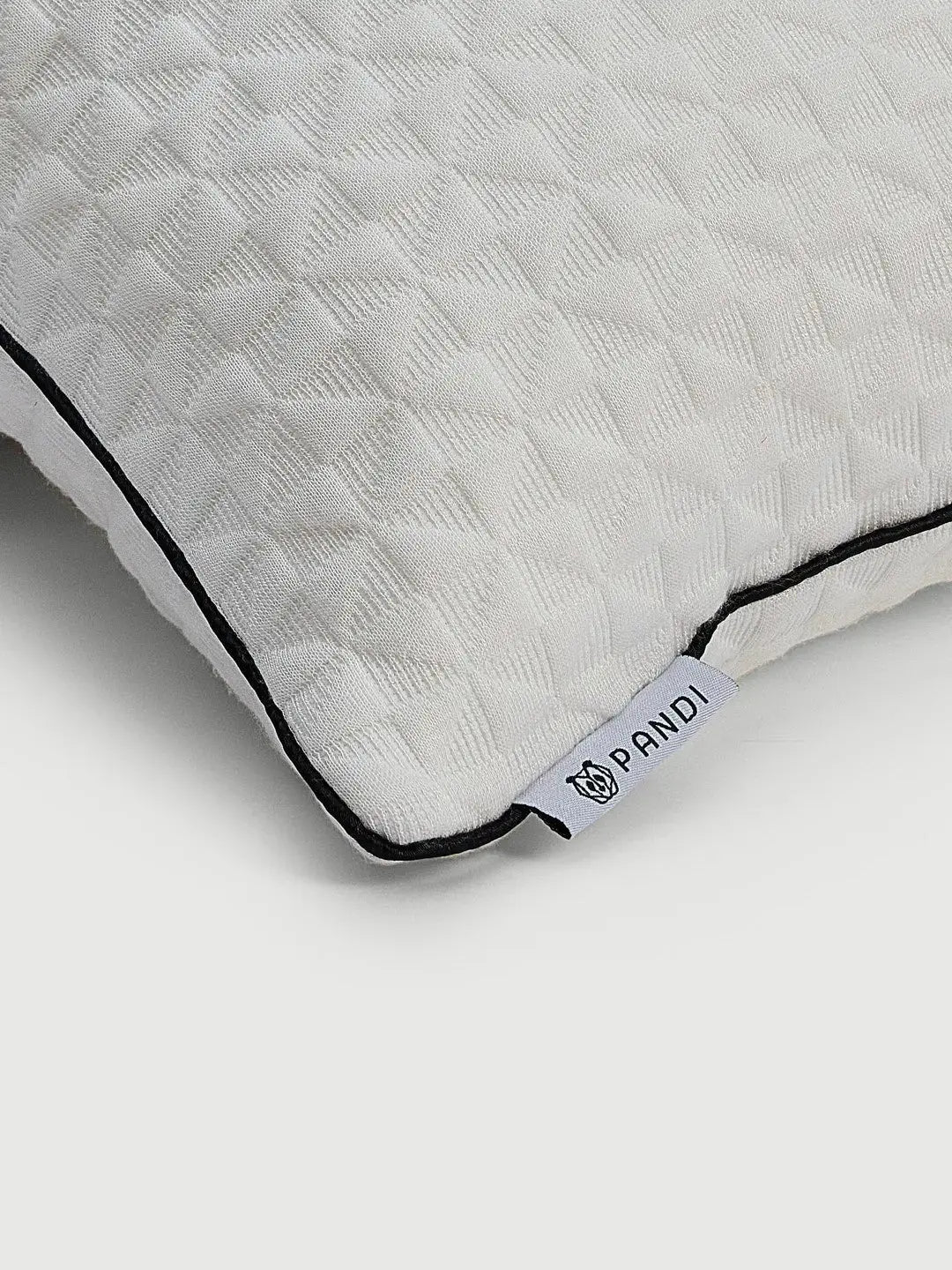 Primer plano de la almohada de soporte lumbar de bambú de PANDI, mostrando su textura suave y la etiqueta de la marca. Una almohada ecológica y ergonómica, ideal para mantener la comodidad y el soporte.