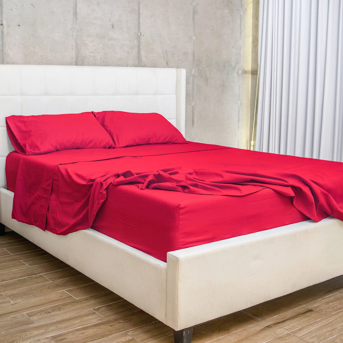 Set de Sábanas 60% Bambú en color rojo sobre una cama moderna con cabecera blanca, ideal para transformar tu dormitorio en un espacio vibrante y acogedor.