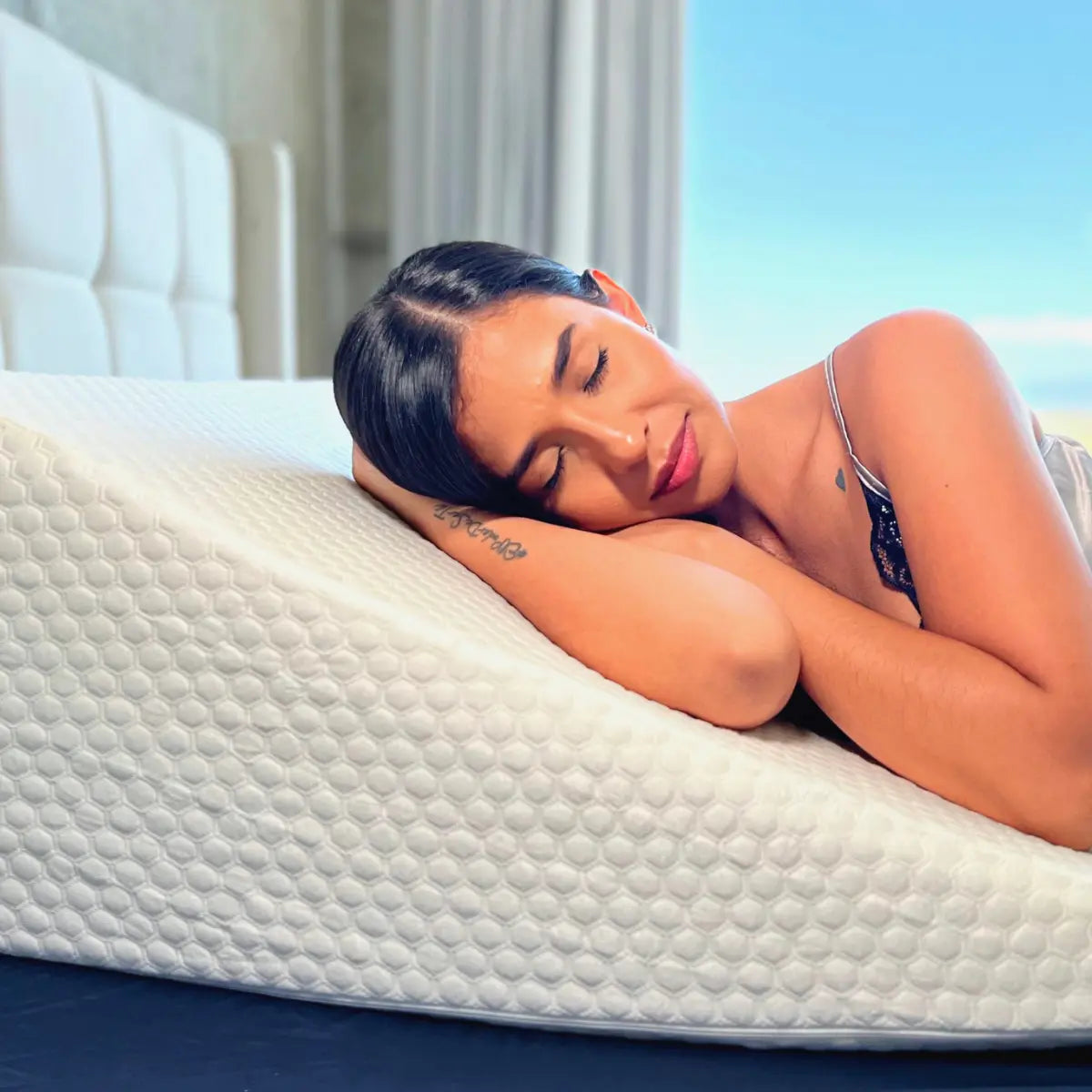 Una mujer relajada duerme plácidamente sobre una almohada alta viscoelástica, mejorando su descanso y bienestar, como se destaca en el artículo 'Almohadas Altas: Mejorando Tu Sueño y Bienestar'.