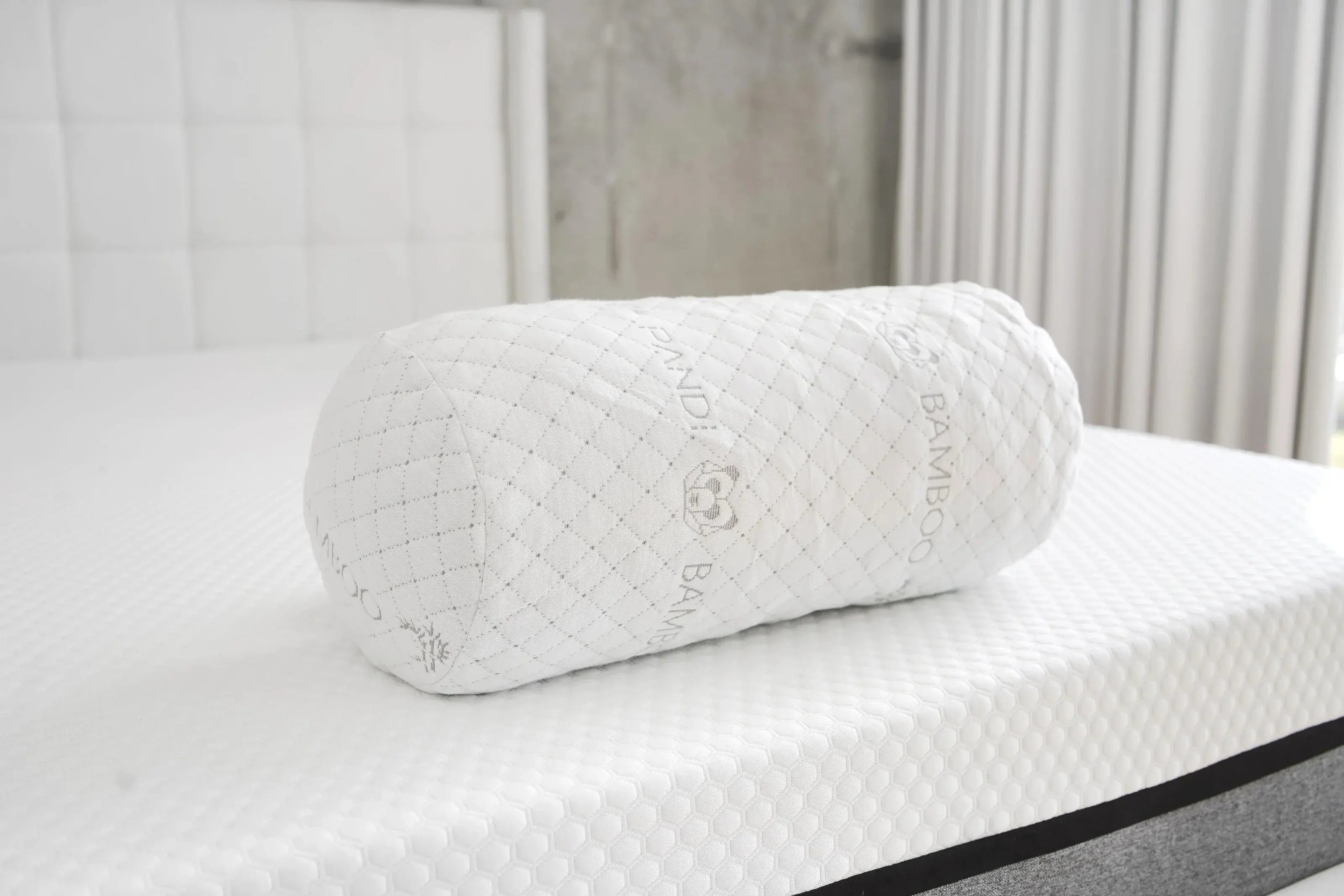 Almohada bolster de bambú sobre un colchón cómodo, destacando sus propiedades ergonómicas y saludables, parte de la colección de Pandi Luxury Bedding en Costa Rica.