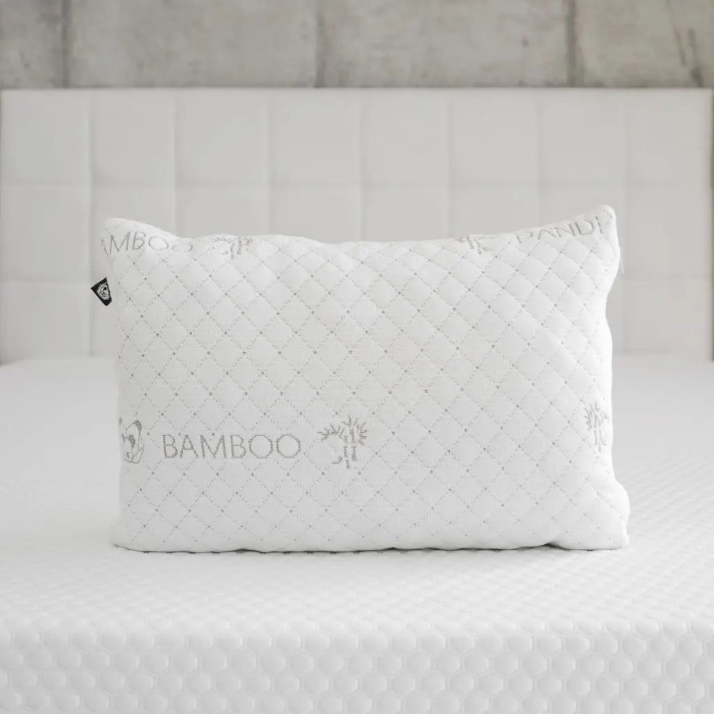 Almohada de Bambú de Pandi Luxury Bedding en color blanco, diseñada para ofrecer comodidad y un sueño reparador, sobre una superficie texturizada que destaca sus propiedades hipoalergénicas y ergonómicas.