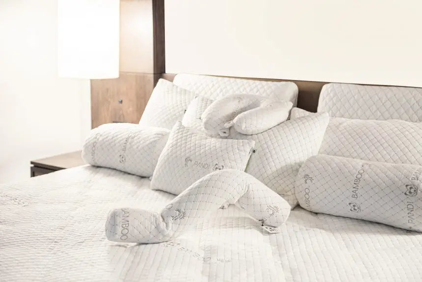 Descubre la almohada lumbar ideal para tu salud en Costa Rica, mostrando una variedad de almohadas de Pandi Luxury Bedding en un ambiente acogedor y moderno.