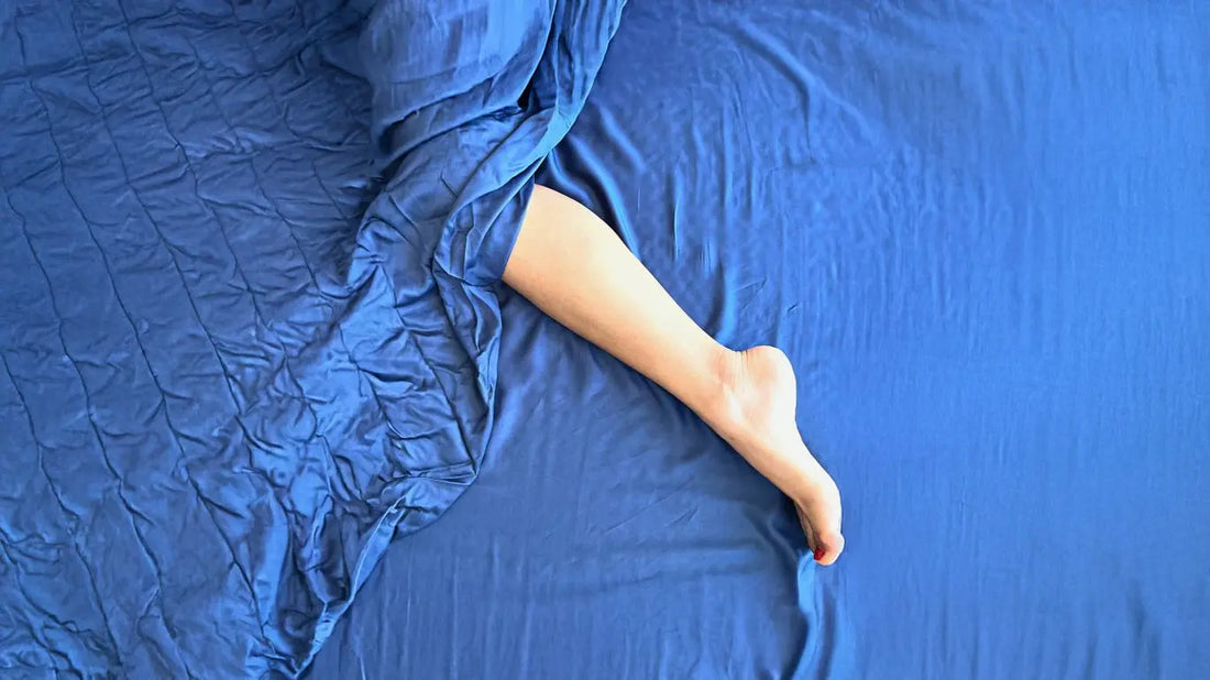 Una pierna descansando sobre sábanas de bambú, simbolizando los beneficios de la ropa de cama de bambú para un sueño saludable.