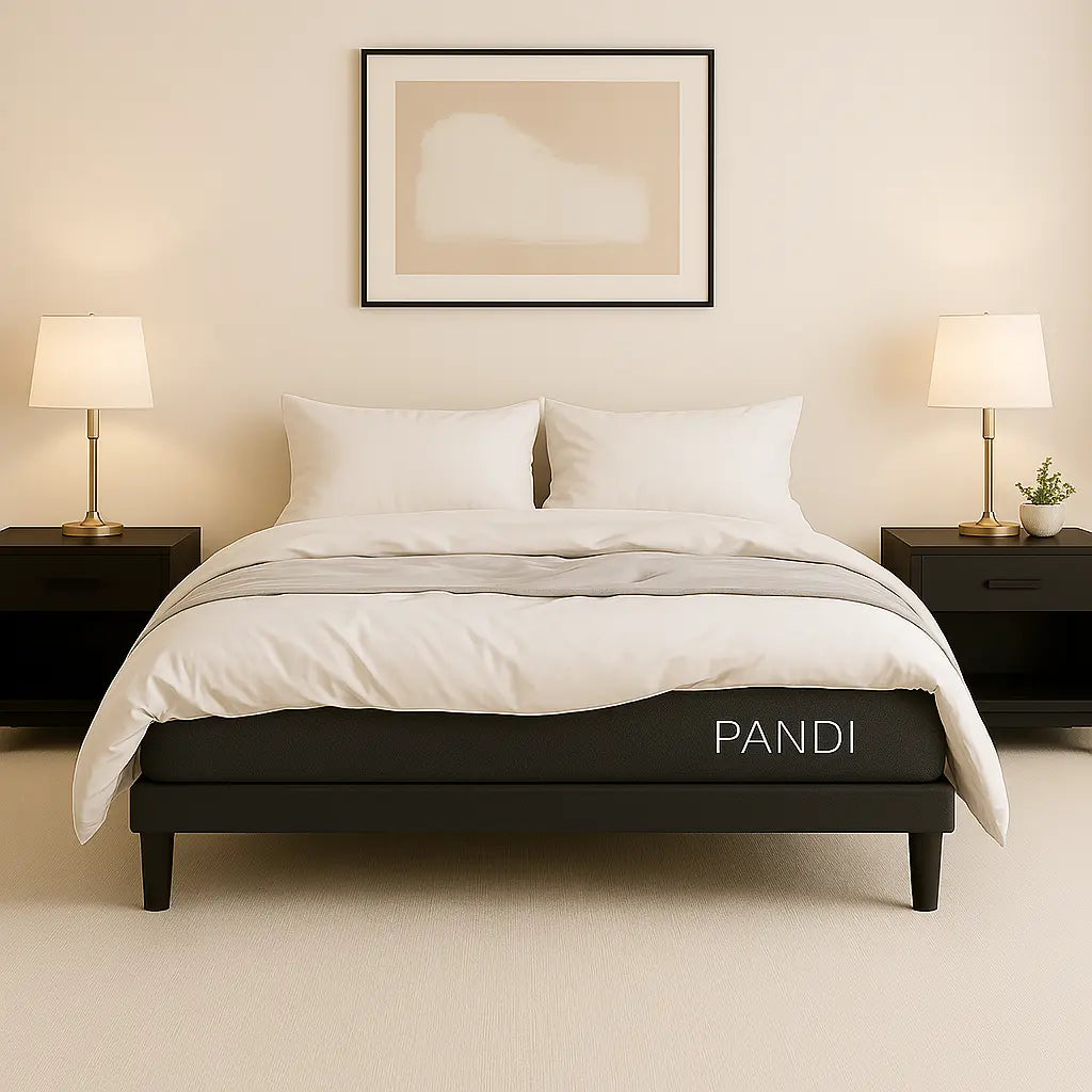 Base de cama de PANDI en un dormitorio moderno, con sábanas blancas, lámparas de mesa y mesas de noche, creando un ambiente elegante y funcional.