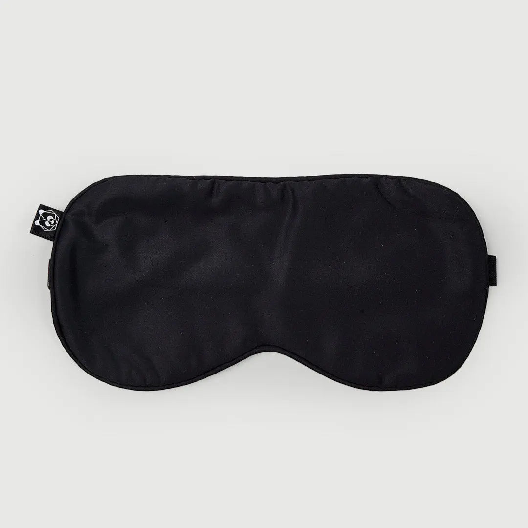 Antifaz - Negro, máscara de ojos de bambú orgánico para un descanso reparador, vista frontal sobre fondo claro.