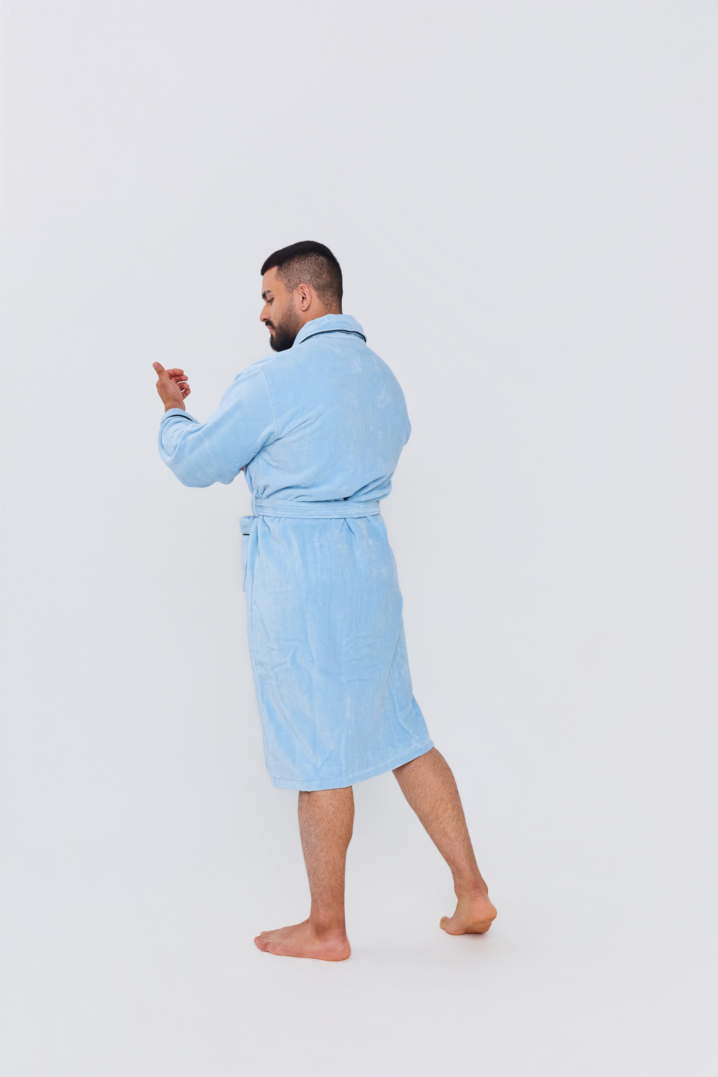 Modelo vistiendo la bata de baño celeste de Pandi, mostrando su diseño moderno y cómodo en un ambiente hogareño.