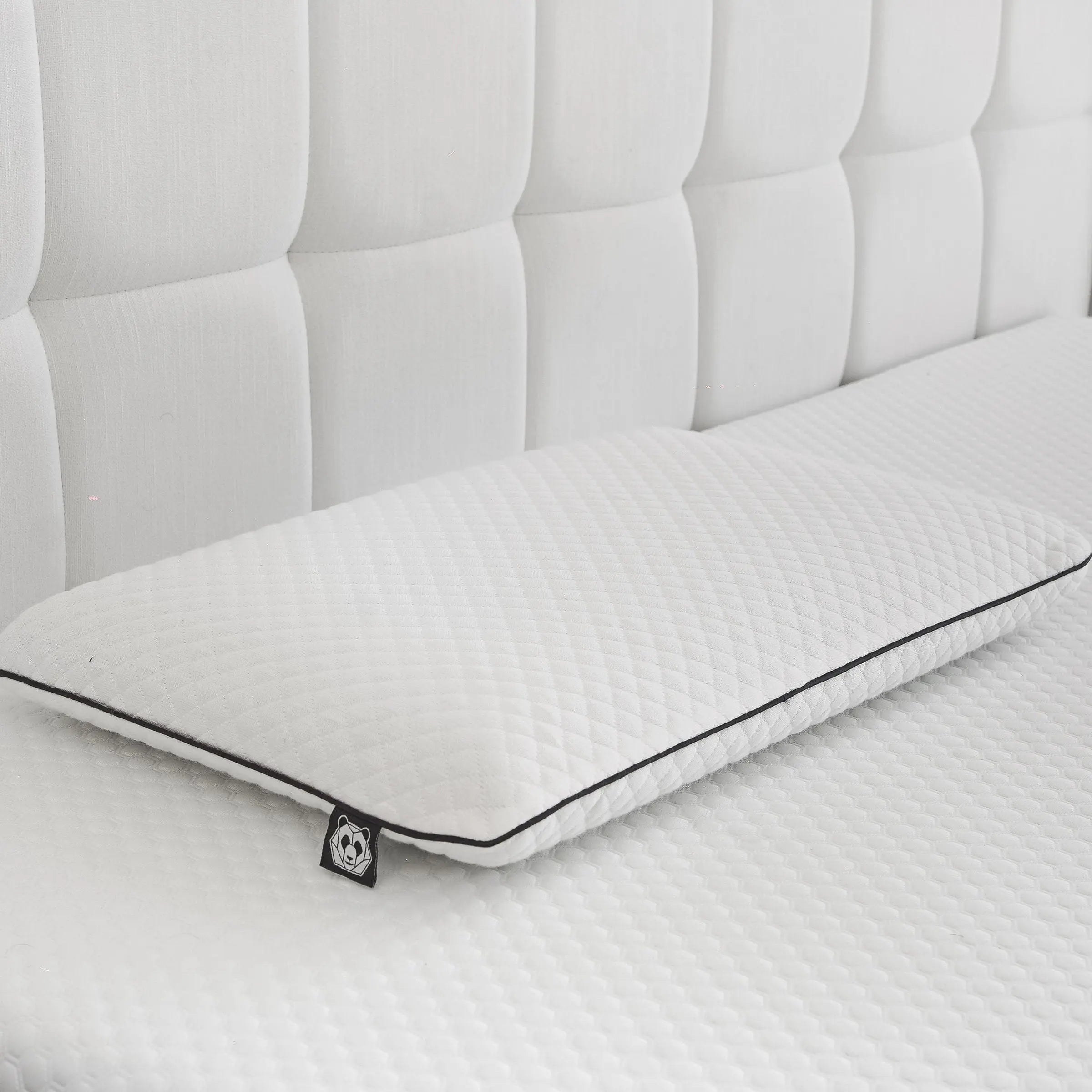Almohada ortopédica para niños de PANDI, diseñada para ofrecer soporte y comodidad, ubicada sobre un colchón blanco en un entorno moderno.