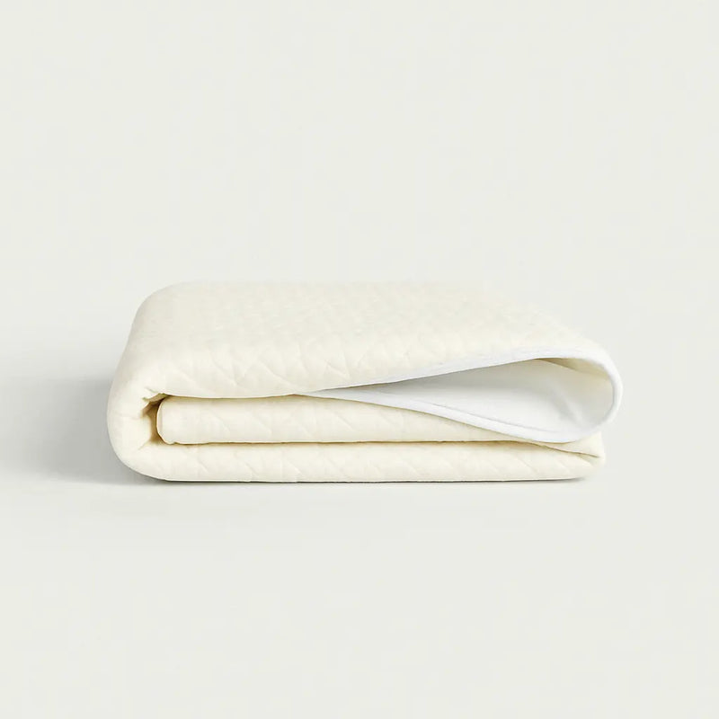 Protector de Colchón de Bambú PANDI doblado, evidenciando su portabilidad y facilidad de almacenamiento, ideal para mantener la frescura y limpieza del colchón.