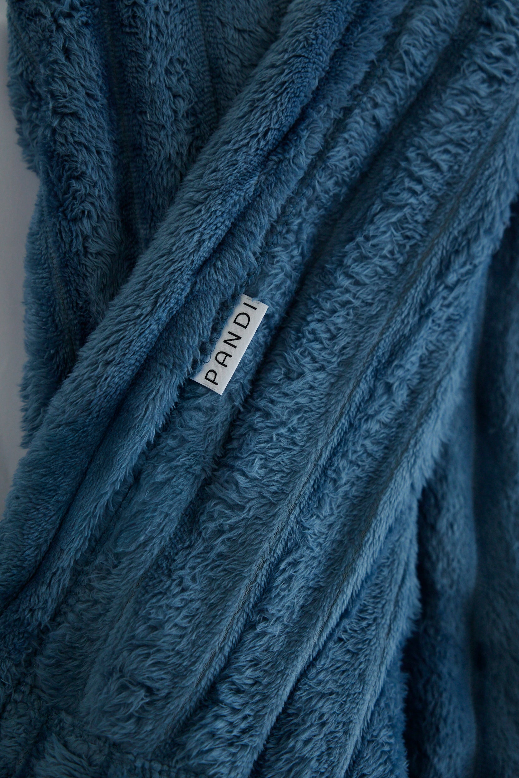 Manta Cuzy - Azul, ideal para noches acogedoras y tardes relajadas en el sofá, fabricada con tela de alta calidad.