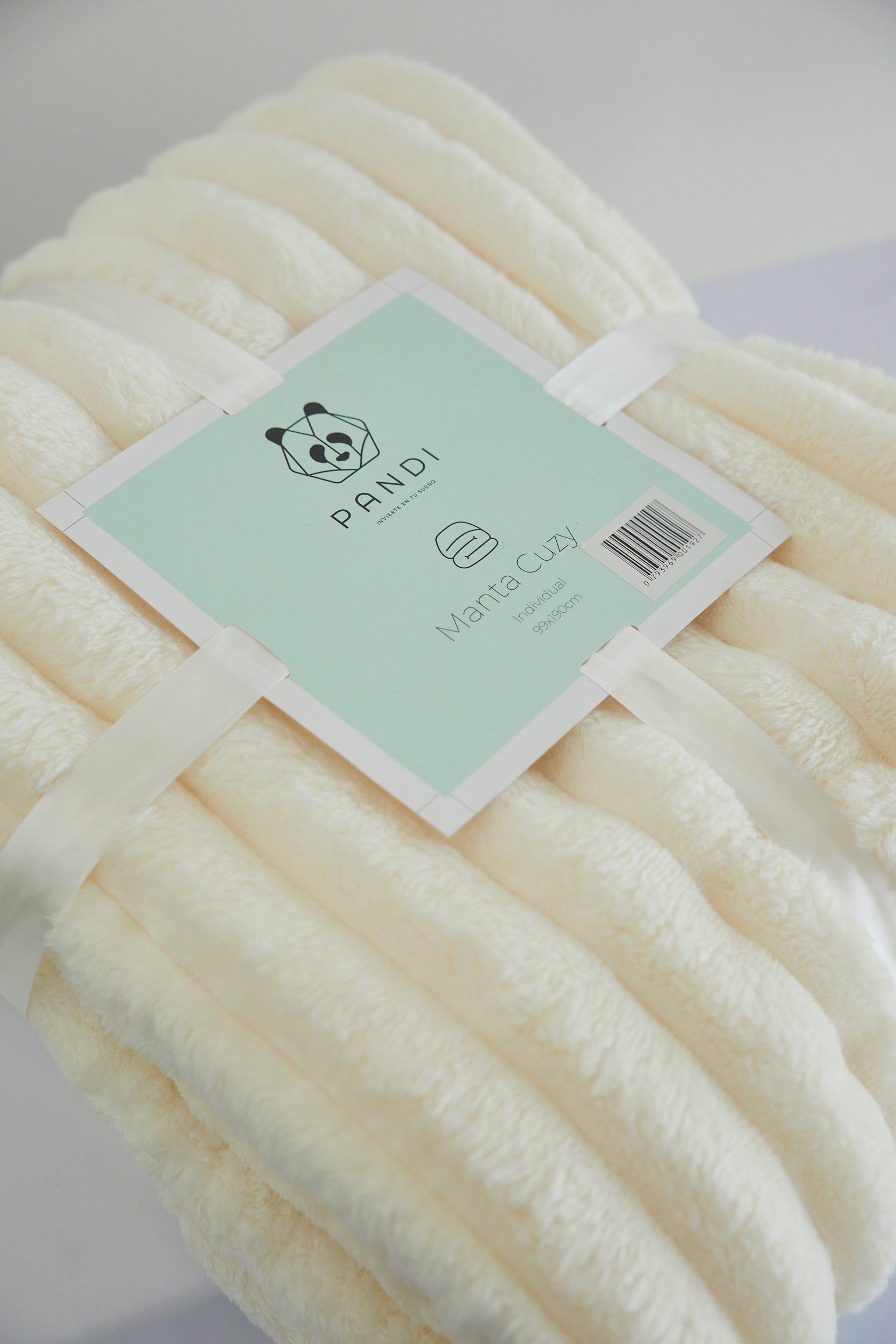 Manta Cuzy - Crema, la elegante manta de franela suave que combina durabilidad y confort, ideal para usar en casa o llevar de viaje.