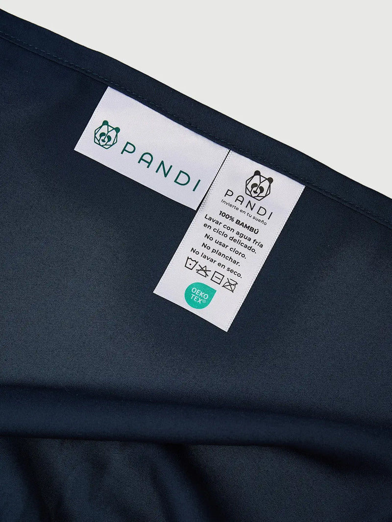 Etiqueta del Set de Sábanas 100% Bambú de PANDI en azul marino, con instrucciones de lavado y certificaciones, mostrando la calidad y cuidado del producto para un descanso óptimo.