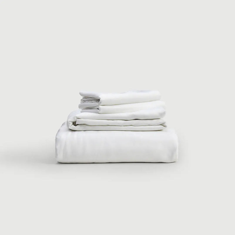 Set de sábanas 100% bambú PANDI en color blanco, apiladas elegantemente sobre un fondo suave. Perfectas para un descanso lujoso y cómodo.