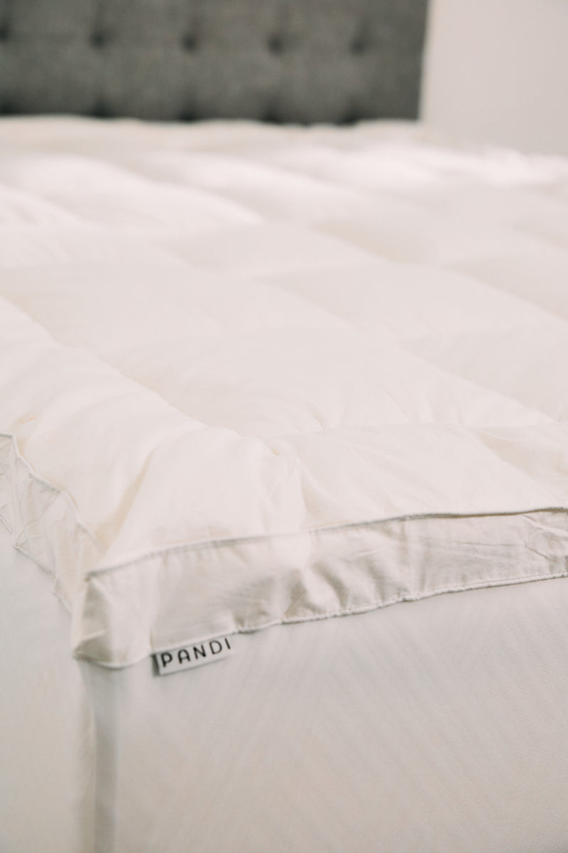 Topper NUBETOP de PANDI en un entorno acogedor, ideal para quienes buscan confort extra en su descanso.