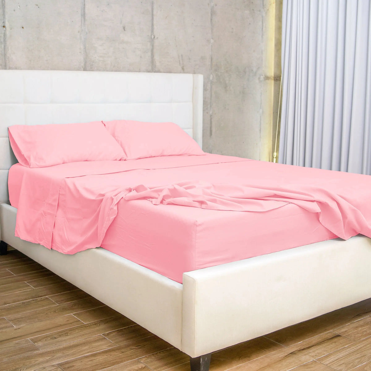 Set de Sábanas 60% Bambú en color Rosa, colocado sobre una cama moderna con cabecera blanca, destacando su suavidad y elegancia en un dormitorio contemporáneo.