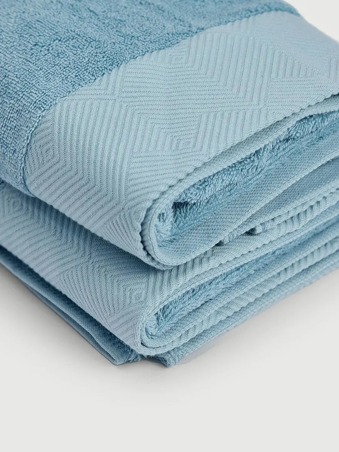 Toalla de mano celeste de PANDI, vista detallada con pliegues y textura suave, perfecta para una experiencia de confort diario.