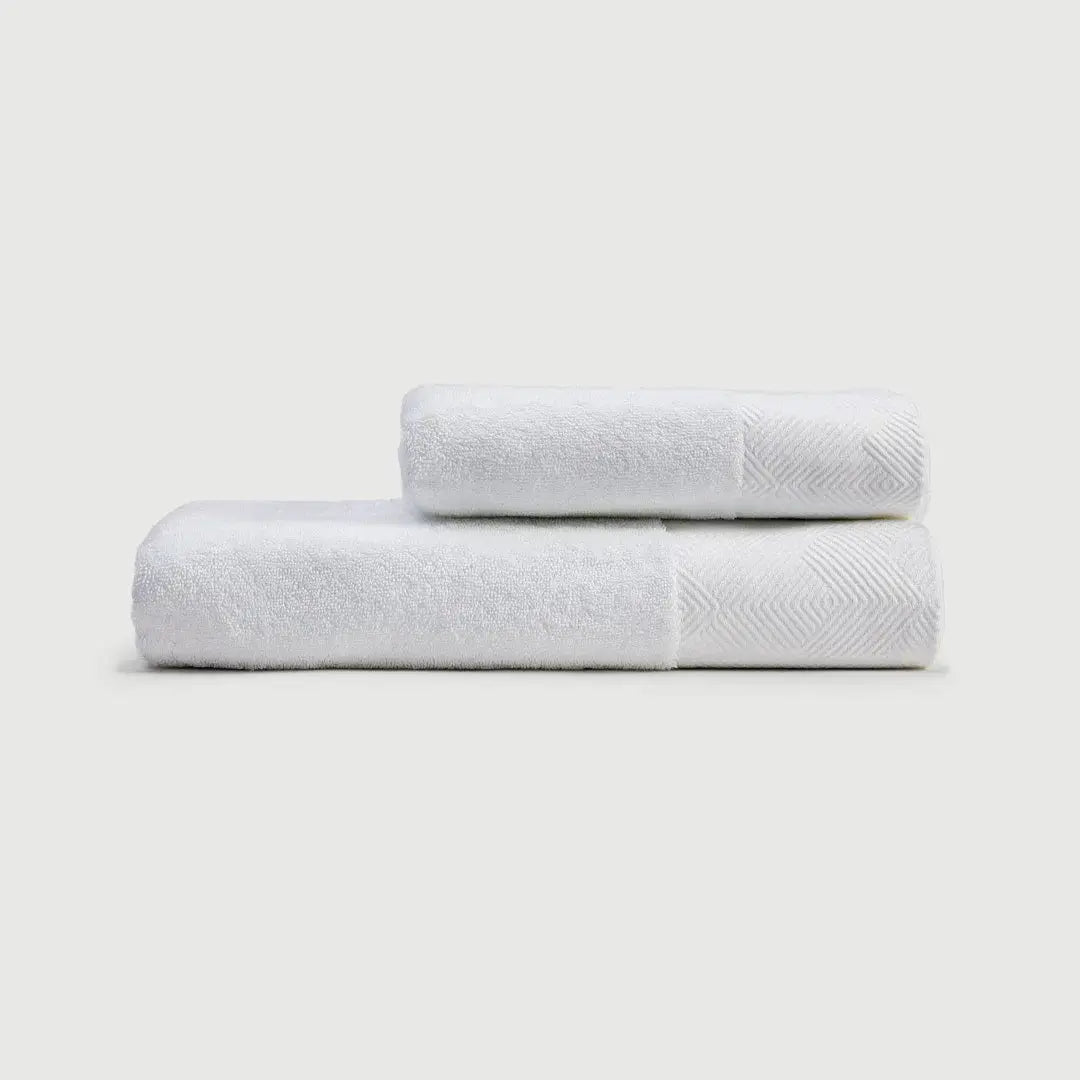 Toallas de mano PANDI en color blanco, apiladas, mostrando su suavidad y diseño elegante para complementar tu baño.