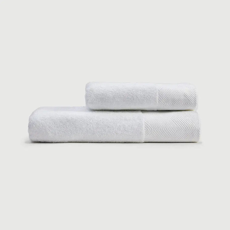 Toallas de mano PANDI en color blanco, apiladas, mostrando su suavidad y diseño elegante para complementar tu baño.
